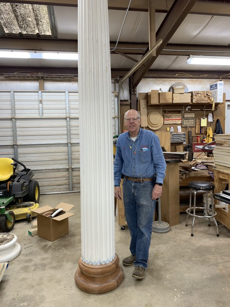 Hugh standing beside a large victorian porch column